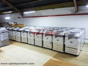 Rows of new copiers wrapped in plastic for protection, ready for copier rental from Optimus Copier company in Malaysia.
