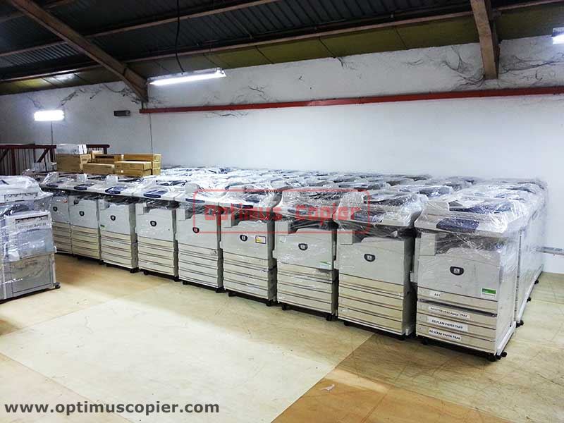 Rows of new copiers wrapped in plastic for protection, ready for copier rental from Optimus Copier company in Malaysia.